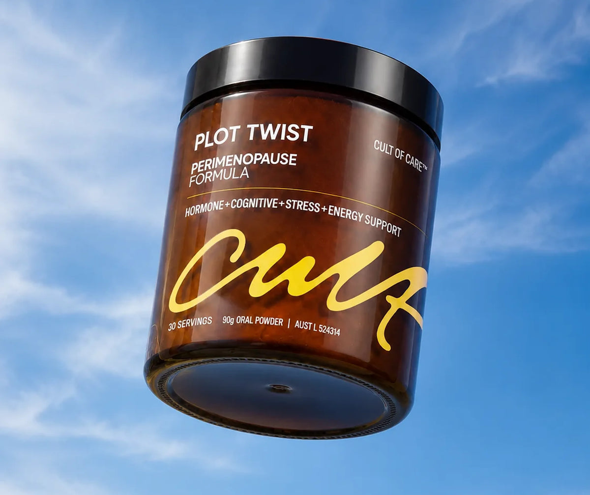 A brown amber jar of Plot Twist Perimenopause Formula by Cult of Care, floating against a blue sky with light clouds. The jar has a black lid and features white and yellow text on the label.